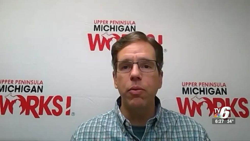 Tim Hyde sits in front of a UPMW background while conducting an interview.