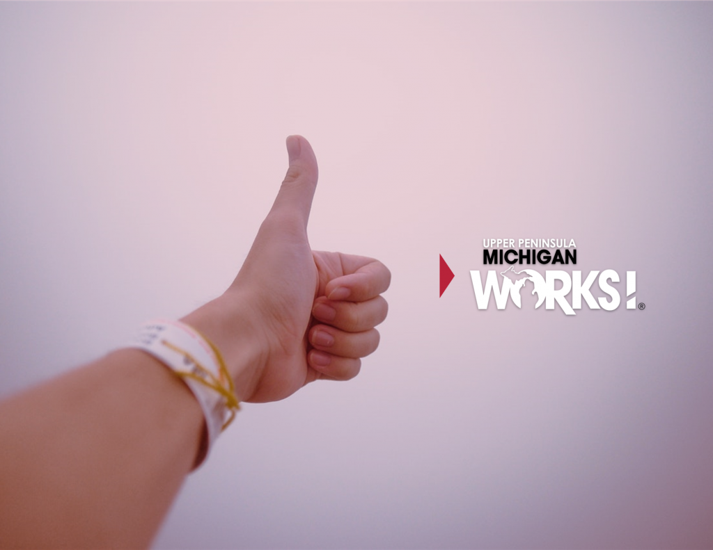 A person gives a thumbs up with the UP Michigan Works logo overlayed.