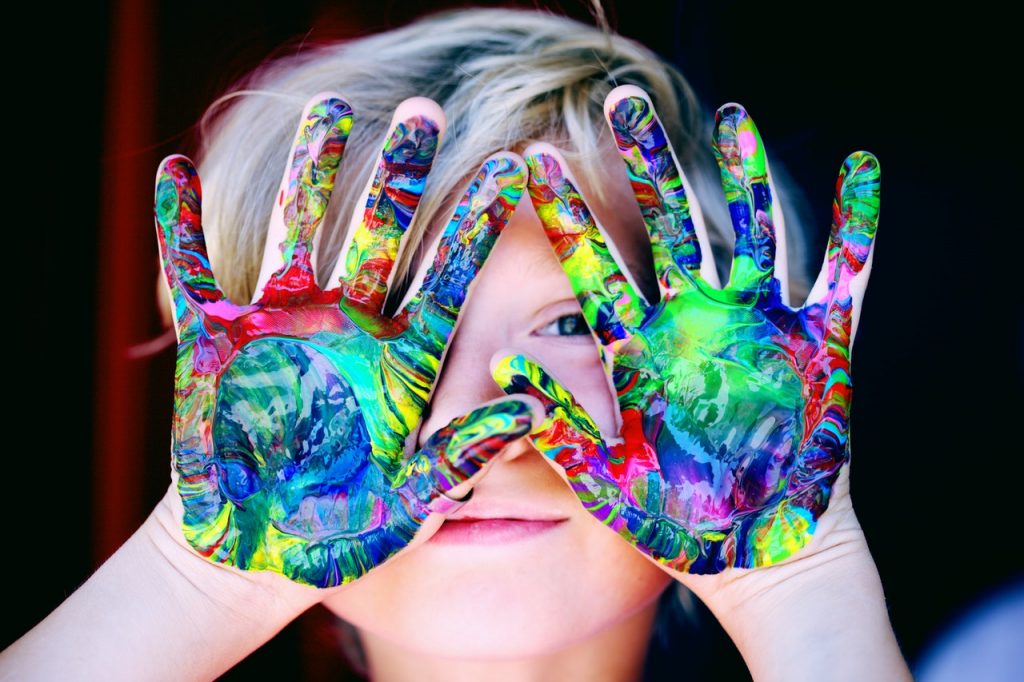 A picture of a child with paint on its hands to promote the Childcare Virtual Job Fair.