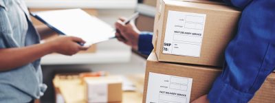 Courier signing document with packages in hand