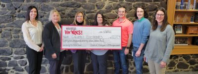 Staff from Michigan Works! present a big check to a local employer.